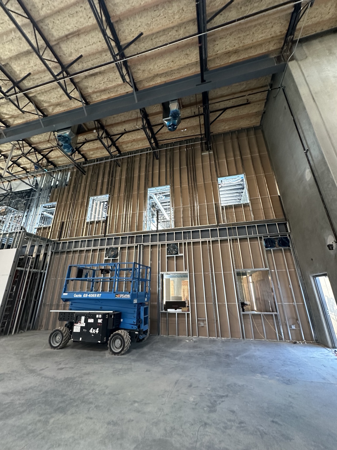 Tall commercial wall framing with a lift in the work area